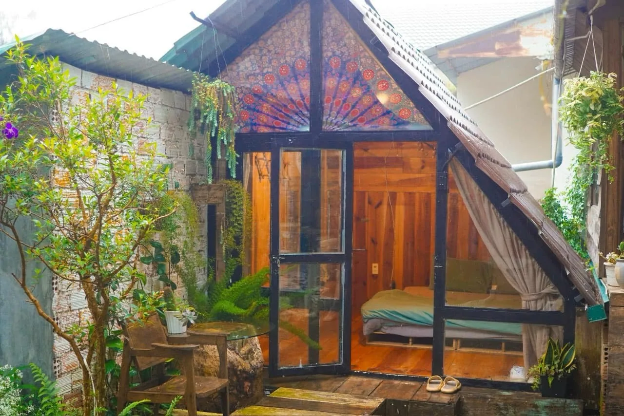 Mặt trước Nhà bên đồi với mái dốc và cửa sổ gỗ giữa rừng thông Đà Lạt